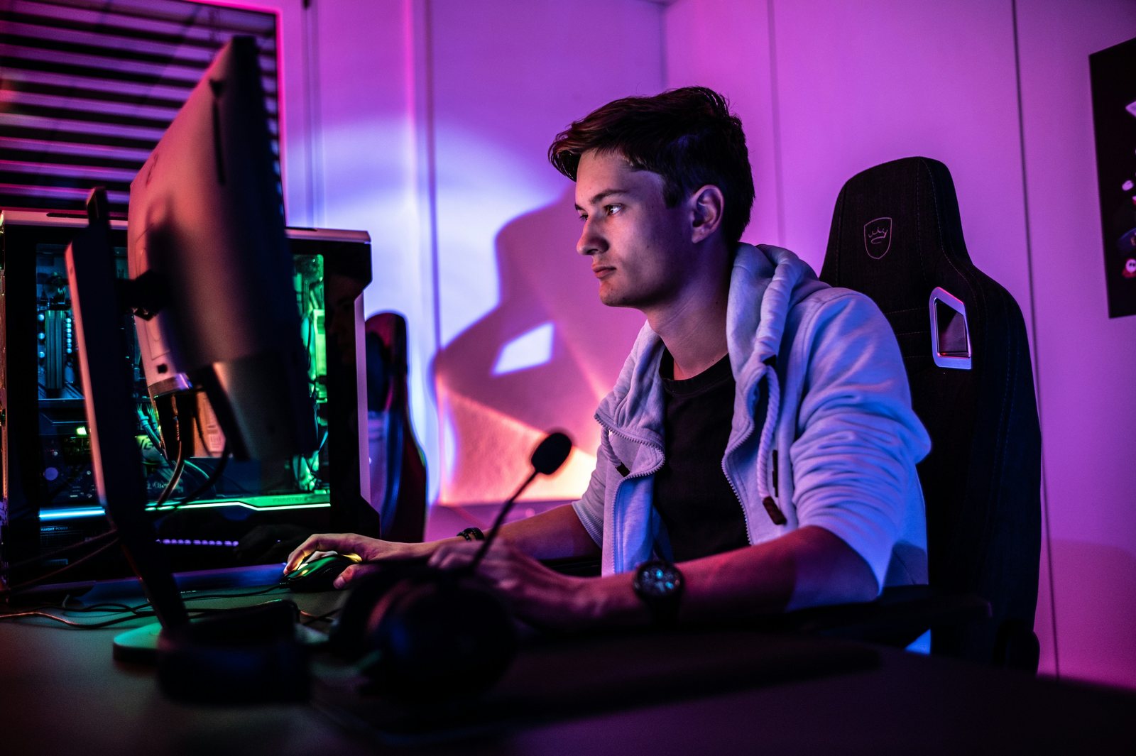 a man wearing headphones and sitting at a desk with a computer